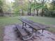 Outdoor picnic table and bench set on a concrete slab surrounded by greenery and trees at 11921 Se 169Th Avenue Rd, Ocklawaha, FL 32179