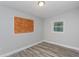 A gray bedroom with modern flooring, one boarded window and one new window at 1325 42Nd St, Orlando, FL 32839