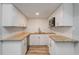 A compact modern kitchen is showcasing bright white cabinets, a granite countertop, subway backsplash and stainless steel appliances at 1325 42Nd St, Orlando, FL 32839