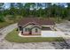 Aerial view of a single-story home with a covered carport and lush landscaping in a private, wooded area at 13491 E Hwy 316, Fort Mc Coy, FL 32134