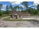 Charming single-story home featuring a covered carport and a well-maintained lawn surrounded by lush trees at 13491 E Hwy 316, Fort Mc Coy, FL 32134