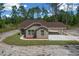 Charming single-story home featuring a covered carport and a well-maintained lawn surrounded by lush trees at 13491 E Hwy 316, Fort Mc Coy, FL 32134