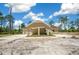 Single-story home featuring a covered carport and a well-manicured lawn against a picturesque wooded backdrop at 13491 E Hwy 316, Fort Mc Coy, FL 32134