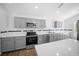 Gray kitchen featuring stainless steel appliances, tiled backsplash, and bright lighting at 13491 E Hwy 316, Fort Mc Coy, FL 32134