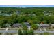 Aerial view of a home in a wooded neighborhood, with a screened pool, mature trees, and a manicured front lawn at 14476 Sw 43Rd Court Rd, Ocala, FL 34473