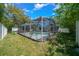 A spacious backyard featuring a screened-in pool, lush landscaping, and plenty of room for outdoor activities and relaxation at 14476 Sw 43Rd Court Rd, Ocala, FL 34473