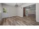 Living room with wood-look floors, modern lighting, and easy access to the entryway and other living spaces at 14476 Sw 43Rd Court Rd, Ocala, FL 34473