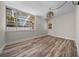 Bright living room featuring wood-look floors, a modern light fixture, large windows, and access to the outdoors at 14476 Sw 43Rd Court Rd, Ocala, FL 34473