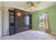 Cozy bedroom with a built-in shelving unit, ceiling fan and lots of natural light from the window at 1453 Ne 161St Pl, Citra, FL 32113