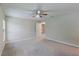 Another view of the bedroom with plush carpeting, showing the ceiling fan, and closet access at 1453 Ne 161St Pl, Citra, FL 32113