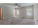 Spacious bedroom with neutral walls, plush carpeting, a ceiling fan, and bright windows for natural light at 1453 Ne 161St Pl, Citra, FL 32113