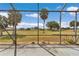 Backyard patio with view of palms and landscaping with golf course in the background at 15239 Sw 15Th Terrace Rd, Ocala, FL 34473