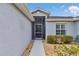 Close up of the screened entrance with gray siding, a front door, and manicured landscaping at 15239 Sw 15Th Terrace Rd, Ocala, FL 34473