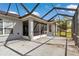 Rear view showcasing the home's screened patio, complementing the lush green lawn at 15239 Sw 15Th Terrace Rd, Ocala, FL 34473