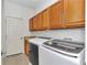 Laundry room with wooden cabinets and modern washer and dryer at 15239 Sw 15Th Terrace Rd, Ocala, FL 34473
