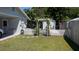 Fenced backyard featuring a well-maintained lawn, landscaping, and an arbor at 2219 Ne 18 Ave, Ocala, FL 34470