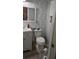 Compact bathroom with a clean white toilet, vanity, and leaf-patterned wallpaper at 2219 Ne 18 Ave, Ocala, FL 34470