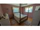 Cozy bedroom featuring a four-poster bed, soft lighting, and a comfortable ambiance at 2219 Ne 18 Ave, Ocala, FL 34470