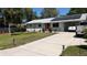 Charming single-story home featuring solar panels, a red front door, and driveway at 2219 Ne 18 Ave, Ocala, FL 34470