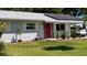 Charming home with solar panels, a red front door, and well-maintained landscaping at 2219 Ne 18 Ave, Ocala, FL 34470