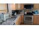 Close-up of the kitchen area with stainless steel appliances and light countertops with a metallic backsplash at 2219 Ne 18 Ave, Ocala, FL 34470