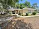 Single-story home featuring a neutral color scheme, simple landscaping, and a red front door at 26 Hemlock Circle Way, Ocala, FL 34472