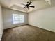 A simple, carpeted room with a ceiling fan and a window with natural light at 26 Hemlock Circle Way, Ocala, FL 34472