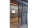Inside the barn, a sturdy stall features concrete walls, a barred window, and a metal mesh sliding door at 2630 Nw 140Th St, Citra, FL 32113