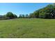 Expansive grassy field with perimeter fencing and trees under a bright, clear sky at 2630 Nw 140Th St, Citra, FL 32113