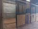 Interior view of horse stalls with ample room, featuring metal bars and wood paneling for secure and comfortable housing at 2630 Nw 140Th St, Citra, FL 32113