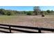 Large land with hay bale, horses, and black fencing under a clear blue sky at 2630 Nw 140Th St, Citra, FL 32113