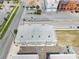 Aerial view of gray and tan townhouses with a flat, gray roof, parking and nearby streets on a sunny day at 288 N Oak Ave, Sanford, FL 32771