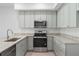 Well-equipped kitchen featuring stainless steel appliances, light gray cabinets, and granite countertops at 288 N Oak Ave, Sanford, FL 32771