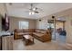 Living room featuring a large brown leather couch, ceiling fan, and sliding glass doors to the patio at 2940 N Huron Dr, Deltona, FL 32738
