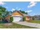 Side view of a well maintained single-story home with an attached two car garage and ample yard space at 2940 N Huron Dr, Deltona, FL 32738