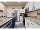 Updated kitchen features stainless steel appliances, granite counters, white cabinets and a tile floor at 3970 Sw 51St Ter, Ocala, FL 34474