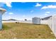 View of a large, fenced backyard featuring a storage shed and patio seating under a sunny sky at 4881 Se 91St Pl, Ocala, FL 34480