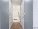 Hallway view into the primary bathroom featuring blue walls, neutral flooring and trim, and a tub at 4881 Se 91St Pl, Ocala, FL 34480
