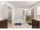 Bright bathroom featuring dual shower, a soaking tub, tile flooring, and double vanity sinks at 4881 Se 91St Pl, Ocala, FL 34480