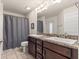 Bathroom with double sink vanity with granite counter tops, tile flooring, and shower with curtain at 4881 Se 91St Pl, Ocala, FL 34480