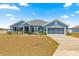 Charming single-story home featuring a beautiful blue exterior, well-manicured lawn, and an attached two-car garage at 4881 Se 91St Pl, Ocala, FL 34480