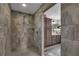 A walk-in shower in a bathroom, featuring tiled walls and floor and a modern showerhead at 5090 Nw 80Th Avenue Rd, Ocala, FL 34482