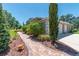 Well-maintained home exterior with a brick walkway leading to a two-car garage and lush landscaping at 5090 Nw 80Th Avenue Rd, Ocala, FL 34482