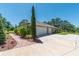 View of the side of a home showcasing a spacious two-car garage, complemented by a brick walkway and lush greenery at 5090 Nw 80Th Avenue Rd, Ocala, FL 34482