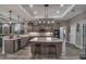 Well-lit kitchen with stainless steel appliances, custom cabinets, a large island and bar seating at 5090 Nw 80Th Avenue Rd, Ocala, FL 34482