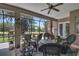 Outdoor patio features ceiling fan, charming decor, and lovely views of a fenced backyard and a lush green space at 5090 Nw 80Th Avenue Rd, Ocala, FL 34482