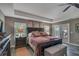 The main bedroom offers a spacious layout, a ceiling fan, and plenty of natural light from large windows at 5090 Nw 80Th Avenue Rd, Ocala, FL 34482