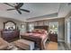The main bedroom features a tray ceiling, a ceiling fan, and plenty of natural light from large windows at 5090 Nw 80Th Avenue Rd, Ocala, FL 34482