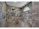 Modern tiled shower featuring a bench, rainfall shower head, and arched window for natural light at 5090 Nw 80Th Avenue Rd, Ocala, FL 34482