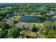 An aerial view shows the condo overlooking a lake with lush surroundings and easy access to a community pool at 515 Midway Dr # A, Ocala, FL 34472